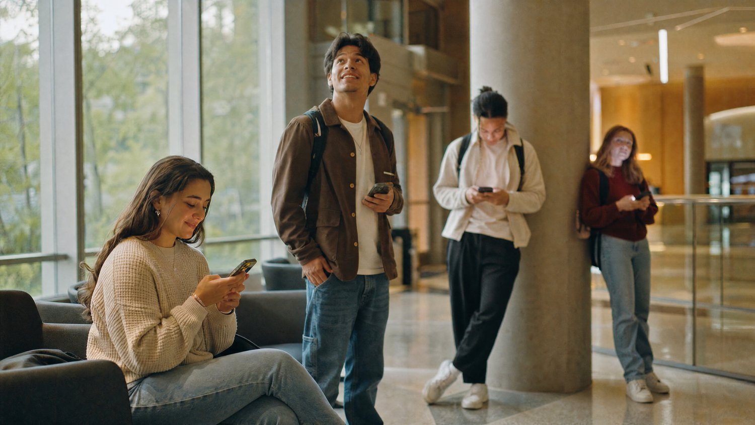Students checking their phones in a campus building